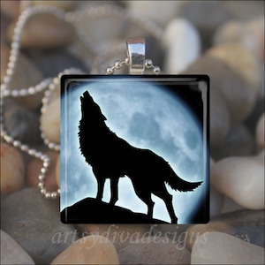 May include: A silver chain necklace with a square glass pendant featuring a black silhouette of a wolf howling at the moon.