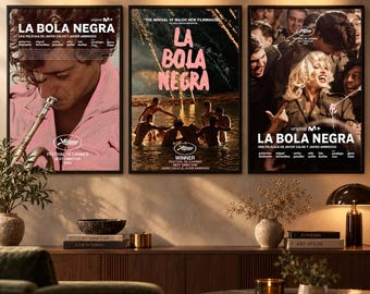 Puede incluir: Tres pósteres de película enmarcados titulados La Bola Negra expuestos en una pared. El póster izquierdo muestra a una persona tocando la trompeta, el central a personas en el agua y el derecho una escena grupal con una persona rubia.