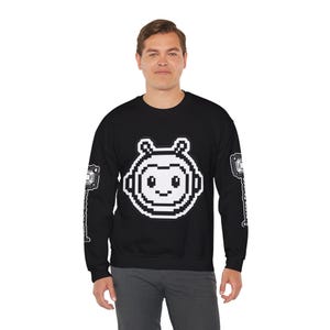 May include: A black long-sleeve sweatshirt featuring a large white pixelated robot head graphic on the centre chest. Each sleeve displays a vertical white pixelated circuit board design. The garment has a crew neckline and ribbed cuffs.