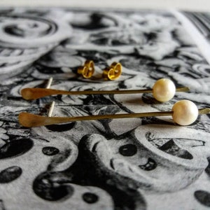 Colgantes dorados con perla.  Simple, lineal.