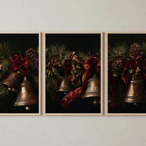 Könnte beinhalten: Ein Triptychon aus drei gerahmten Wandkunstdrucken mit dunklen, stimmungsvollen Illustrationen von metallischen Bronzeglocken, die zwischen grünen Kiefernzweigen, braunen Kiefernzapfen und tiefroten Samtbändern vor einem einfarbigen schwarzen Hintergrund hängen.