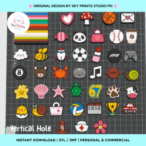 May include: A collection of small, colorful 3D-printed charms featuring various icons including animals, sports equipment, food, and symbols. The grid layout displays items like a panda, bee, soccer ball, rocket, musical note, and a trophy on a dark background.