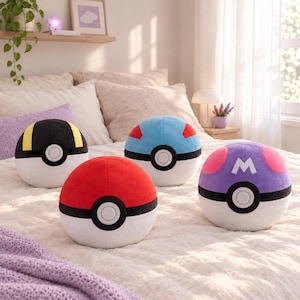 Peut inclure: Quatre jouets en peluche sphériques ressemblant à diverses Poké Balls. L'une est rouge et blanche, une noire et jaune, une bleue et blanche avec des accents rouges, et une violette et blanche avec des cercles roses et un M blanc sur le dessus.