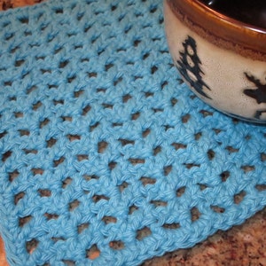 May include: A blue crocheted square dishcloth or pot holder. The dishcloth is made with a simple stitch pattern and has a textured surface.