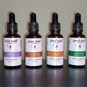May include: Eight amber glass bottles with black dropper caps, each containing 1 fl oz of essential oil. The white labels feature the text good stuff aromatics, a rose icon, and scent names including rose, sandalwood, lilac, cinnamon, orange, patchouli, helichrysum, and lavender.