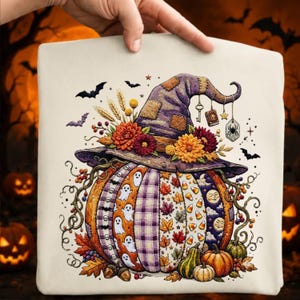Peut inclure: Un sac fourre-tout couleur crème avec une illustration d'une grosse citrouille portant un chapeau de sorcière violet. La citrouille est décorée de motifs de fantômes, de carreaux, de feuilles d'automne, de bonbons et de lunes, avec des fleurs.