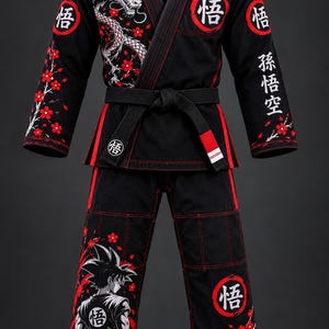 Puede incluir: Un gi de artes marciales negro con gráficos de dragones y flores de cerezo en rojo y blanco. La chaqueta y el pantalón incluyen emblemas circulares rojos con el kanji Go, y la manga izquierda muestra texto japonés vertical en blanco.