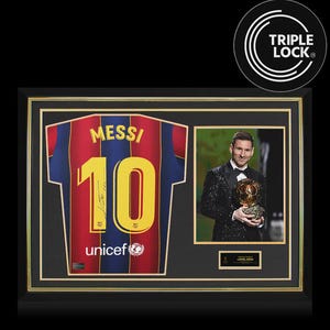 Op de afbeelding: Een ingelijste display met een rood-blauw gestreept voetbalshirt met de naam MESSI en het nummer 10 in het geel gedrukt, inclusief een handtekening. Daarnaast staat een foto van Lionel Messi in smoking met een gouden trofee-bal.