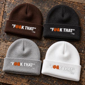 May include: Four cuffed knit beanies in brown, black, gray, and white. Each beanie features the embroidered white text "F@&K THAT" with an orange "@" symbol and a small "-TM" suffix positioned on the front cuff of the hat.
