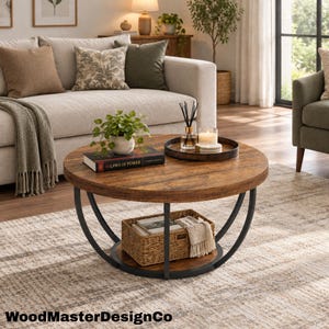 May include: A round coffee table with a brown wood-grain top and a black metal frame. The table features a lower shelf holding a woven basket and a top surface displaying a book titled Laws of Power, a small potted plant, and a round tray with a candle.