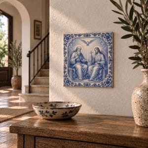 Peut inclure: Un carreau de céramique carré présentant une illustration bleue et blanche de deux personnages assis sur des trônes avec une colombe au-dessus d'eux. Le carreau possède une bordure florale ornée et est fixé au mur. L'œuvre représente une scène religieuse.