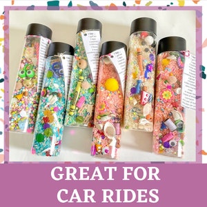 May include: Six clear plastic bottles filled with colorful rice and small objects. The bottles have labels that say "I Spy" and list items to find.  The bottles are a fun activity for kids and are great for car rides.