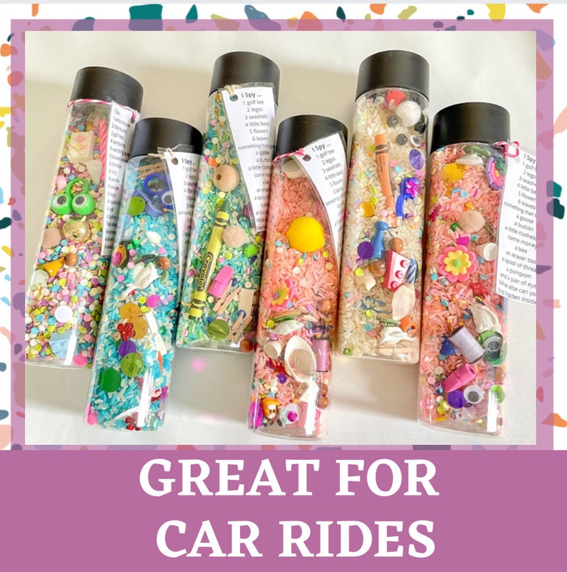 May include: Six clear plastic bottles filled with colorful rice and small objects. The bottles have labels that say "I Spy" and list items to find.  The bottles are a fun activity for kids and are great for car rides.
