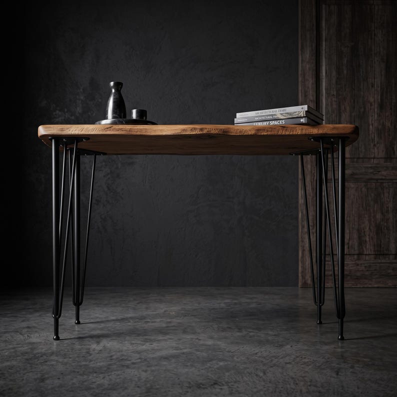 May include: A rectangular wooden table with a natural live edge top and four black metal hairpin legs. On the surface sits a small black bottle, a black cup, and a stack of two books with the visible text Architectural Diary and Luxury Spaces.