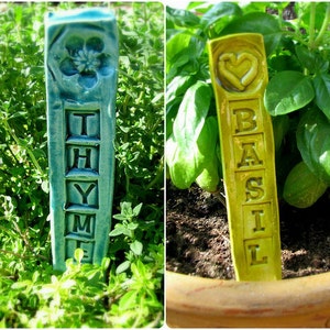 May include: Two ceramic plant markers, one blue with the word "THYME" and one yellow with the word "BASIL".