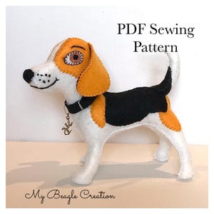 May include: A felt beagle dog toy featuring white, tan, and black patches, a black collar with a small metal lizard charm, and embroidered facial details. The text PDF Sewing Pattern and My Beagle Creation are visible on the image.