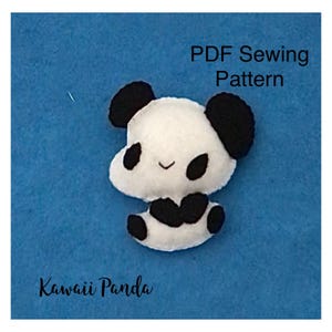May include: A white and black felt panda figure with rounded ears, black eye patches, and a small stitched mouth. The text PDF Sewing Pattern and Kawaii Panda are visible on the blue background, indicating a craft project design.