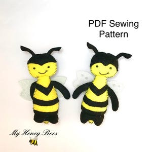 Può includere: Due bambole ape in feltro fatte a mano con corpi a righe gialle e nere, teste nere e ali bianche traslucide. Il testo PDF Sewing Pattern e My Honey Bees è visibile. Ogni ape presenta dettagli cuciti e antenne.