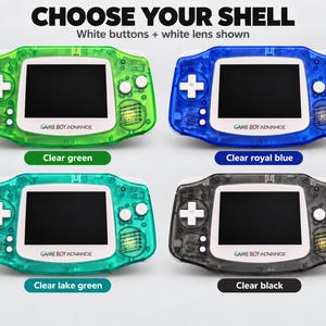 May include: Four Game Boy Advance handheld consoles with transparent shells in clear green, clear royal blue, clear lake green, and clear black. Each features white buttons, a white lens, and the text CHOOSE YOUR SHELL at the top.