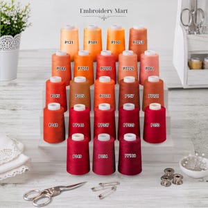 May include: A collection of twenty-five spools of embroidery thread arranged in five rows on a tiered white stand. Each spool features a unique color ranging from light orange to deep burgundy, with labels like P131, P189, P190, P7253, P044, P7278, P7078, P7226, P041, P045, P305, P7021, P157, P7221, P048, P7146, P7037, P7039, P050, P049, P054, and P7186. The text Embroidery Mart is visible at the top.