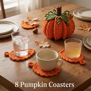 Puede incluir: Un juego de 8 posavasos de calabaza con un diseño de hoja de ganchillo de color naranja vibrante y una superficie texturizada. El juego incluye un centro de mesa de calabaza de ganchillo con hojas verdes y un tallo marrón. El texto 8 Pumpkin Coasters es visible.