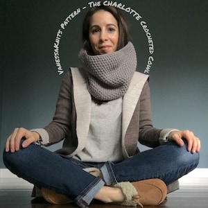 May include: A woman wearing a gray crocheted cowl neck scarf, a brown cardigan, a gray sweater, blue jeans, and brown slippers. The text "Vanessa Knits Pattern - The Charlotte Crocheted Cowl" is written in a circle around the woman's head.