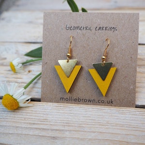 May include: A pair of geometric earrings with a gold triangle layered over a yellow triangle. The earrings are on a brown card with the text "Geometric Earrings" and "molliebrown.co.uk".