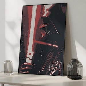 Op de afbeelding: Een ingelijste verticale wandkunstprint met een gestileerde grafische illustratie van een donker figuur met helm die een gloeiend rood lichtzwaard vasthoudt. Het kunstwerk gebruikt een contrastrijk kleurenpalet van diepzwart, donkerrood en wit.