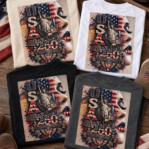 May include: Four t-shirts in beige, white, black, and dark gray featuring a graphic print of the Statue of Liberty, a bald eagle, and the text USA 250 ANNIVERSARY 1776-2026. The design includes a stylized American flag and a close-up of a face.