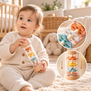 Può includere: Un giocattolo sensoriale cilindrico in legno e plastica trasparente con dischi interni a forma di fiore e piccole perline multicolori. Il giocattolo presenta estremità in legno chiaro e un corpo tubolare trasparente per il movimento.