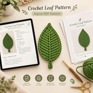 May include: A digital PDF crochet leaf pattern displayed on a tablet and printed paper, featuring a green crocheted leaf, a wooden crochet hook, a ball of green yarn, a green stitch marker, and gold scissors, with text reading Crochet Leaf Pattern.
