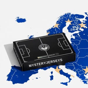May include: A rectangular black cardboard box featuring a white graphic of a football pitch layout on the lid. The text MYSTERYJERSEYS is printed in white on the front edge. A circular logo with a shirt icon and the text MYSTERSHIRT 2021 is centered.