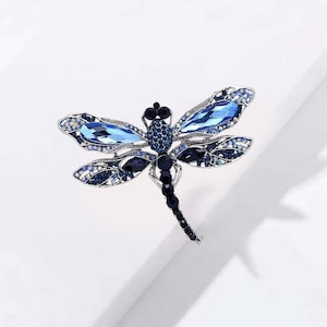 This dragonfly-shaped crystal rhinestone brooch complements coats, suits, dresses, and accessories perfectly.