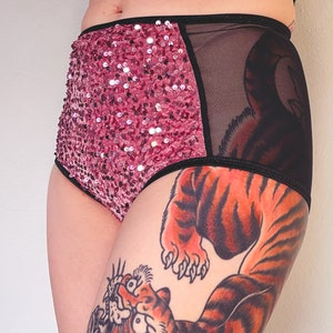 Puede incluir: Ropa interior de cintura alta de lentejuelas rosas y malla negra con una banda el&aacute;stica negra. La ropa interior tiene un tatuaje de tigre en la pierna.