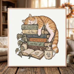 May include: A cross-stitch pattern featuring an orange tabby cat sleeping on a stack of five books. Beside the books is a potted plant with green leaves, an open book, and a ceramic mug with steam rising from it, all on a white grid background.