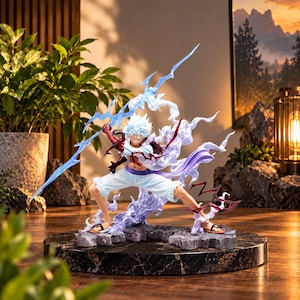 Pode incluir: Uma figura dinâmica de personagem de anime com cabelo branco espetado, calções brancos e sandálias, em posição de combate. A figura está rodeada por efeitos de relâmpagos azuis translúcidos e energia roxa, montada numa base escura.