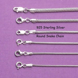 May include: Six silver-coloured round snake chains arranged horizontally, each featuring a lobster claw clasp. The text 925 Sterling Silver Round Snake Chain is printed in black between the third and fourth chains from the top of the image.