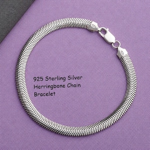 May include: A 925 sterling silver herringbone chain bracelet with a polished finish and a lobster claw clasp. The metal links are arranged in a flat, repeating V-shaped pattern. The text 925 Sterling Silver Herringbone Chain Bracelet is visible.