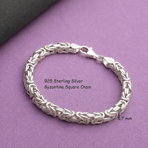 Könnte beinhalten: Ein Armband aus 925er Sterlingsilber mit byzantinischer quadratischer Kette und Karabinerverschluss. Die Metallglieder bilden ein komplexes, gewebtes Muster. Der Text auf dem Bild lautet 925 Sterling Silver Byzantine Square Chain und 5,7 mm.