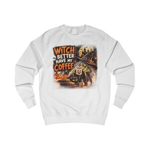 May include: A white long-sleeve sweatshirt featuring a graphic print of a witch holding a coffee mug with a jack-o'-lantern face. The text reads WITCH BETTER HAVE MY COFFEE, surrounded by pumpkins, a black cat, candles, and a haunted house silhouette.