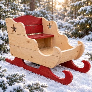 May include: A wooden sleigh featuring a natural light wood finish on the sides and seat, contrasted by a deep red painted backrest and curved runners. Each side panel includes a cutout star shape, and the structure is built from horizontal planks.