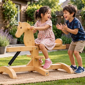 May include: A light-colored wooden spring rocking horse featuring a stylized horse head, a seat, and a black metal coil spring mechanism attached to a sturdy base, designed for outdoor play on a woven mat in a garden setting.