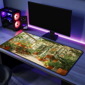 May include: A rectangular desk mat featuring a printed illustration of a sunlit greenhouse filled with various potted green plants and orange flowers. The mat is positioned on a desk surface in front of a computer monitor and a gaming PC tower.