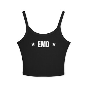 May include: A black sleeveless crop top with thin shoulder straps. The center of the chest features the word EMO printed in bold white capital letters, flanked by a white five-pointed star on both the left and right sides of the text.