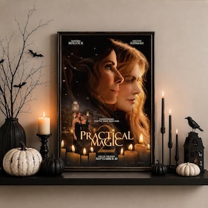 May include: A framed movie poster for Practical Magic 2 featuring Sandra Bullock and Nicole Kidman, with the text Everything You've Witched For, Practical Magic 2, and September 10. The poster is displayed on a shelf with candles and pumpkins.