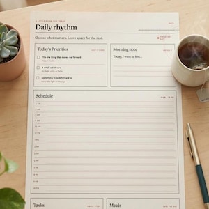 May include: A white daily planner sheet titled Daily rhythm with sections for Today's Priorities, Morning note, Schedule from 6 AM to 10 PM, Tasks, and Meals. The layout includes checkboxes and lined spaces for writing, printed in black ink.