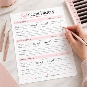 May include: A white paper lash client history form with pink accents and black text. The form includes sections for three appointments, lash maps for left and right eyes, and fields for curl, diameter, lengths, adhesive, client feedback, and artist notes.