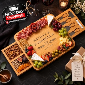 May include: A rectangular bamboo charcuterie board featuring a slide-out drawer, engraved with the text NATHAN & ISABELLA EST. 2026. The board is arranged with assorted cheeses, cured meats, grapes, strawberries, nuts, and dried fruit.