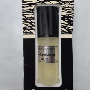 May include: A bottle of Cabochard Eau de Toilette by Gres Paris in its original packaging. The bottle features a frosted glass body, a black ribbed cap, and a silver label with black text. The box has a black and white branch pattern.