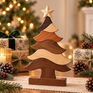 Peut inclure: Une sculpture décorative de sapin de Noël en bois composée de segments horizontaux ondulés empilés dans des tons variés de brun, allant de l'érable clair au noyer foncé. Le sapin est surmonté d'une étoile et repose sur une base rectangulaire.